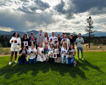 CU Regents and staff show off paintings from a teambuilding exercise at the 2024 Regent summer retreat