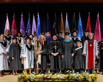 Board of Regents, President Saliman, Chancellor Justin Schwartz pose on stage with award winners at the 2025 CU Boulder Regent Awards cermeony.